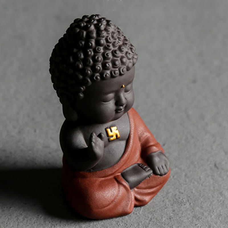 Small Buddha Purple Clay Decoration – solo terracotta-robe Buddha on gray surface, three-quarter close-up, spiritual craft