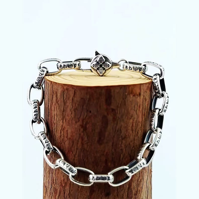 Double Dorje Wisdom Bracelet - Draped on wooden log prop against white background, engraved silver cuff