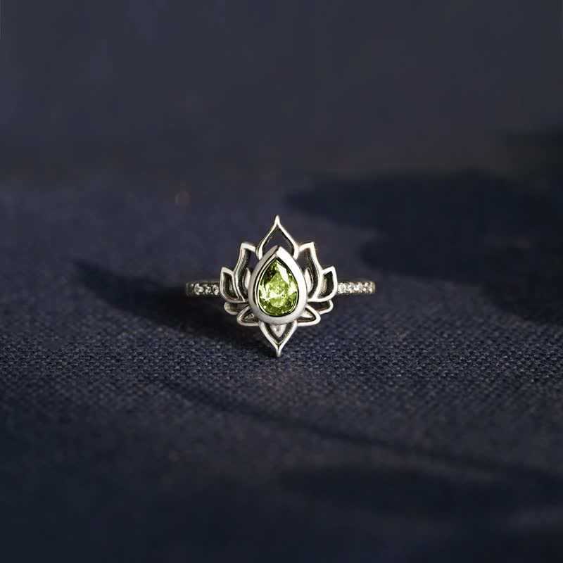 Sterling Silver Lotus Ring – Green peridot lotus on dark fabric, nature-inspired ring