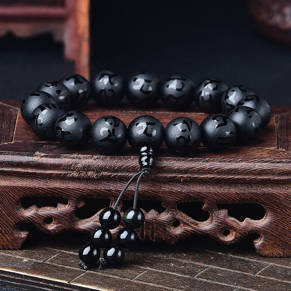 Black Onyx Mantra Bracelet – Black onyx mantra beads on carved wooden display stand
