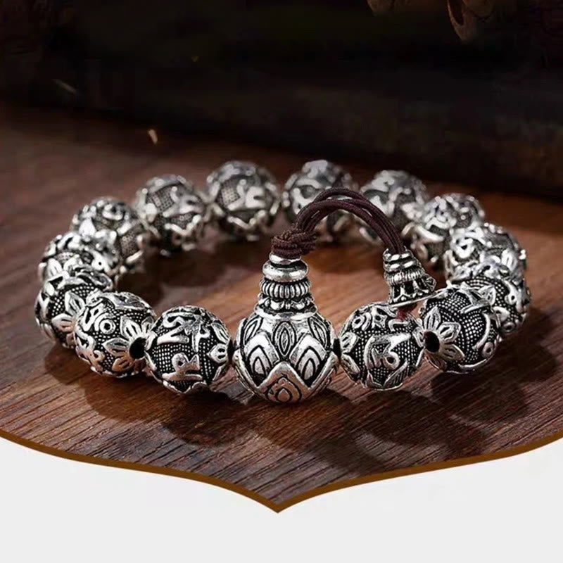 Om Mani Padme Hum Bracelet – Carved silver beads on dark wood, warm artisanal product photo