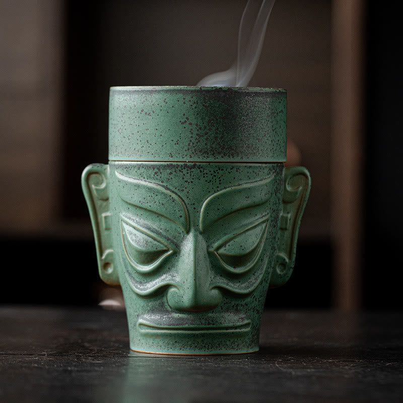 Sanxingdui Bronze Mask Incense Burner – Frontal view with steam rising from lid opening, bronze patina ceramic