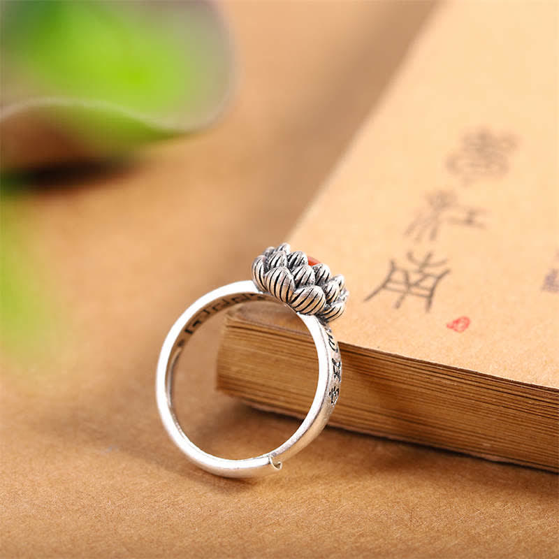 925 Silver Lotus Red Agate Ring – adjustable open band lotus ring with red gemstone center, side view on vintage book, artisan jewelry