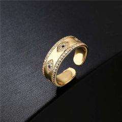 Gold Evil Eye Adjustable Ring with Pavé Crystal Band on Dark Textured Background