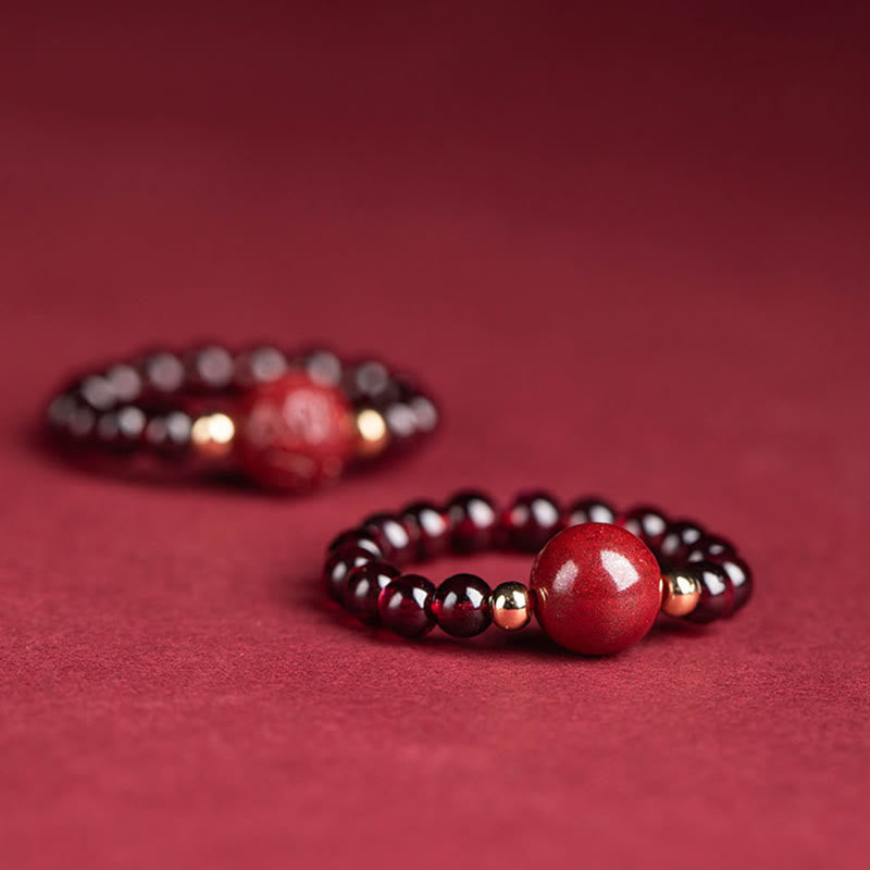 Garnet Cinnabar Ring – two rings foreground cinnabar mantra beads burgundy backdrop, detail