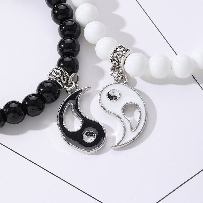 Yin Yang Protection Couple Bracelet - Close-up of black and white stone bead bracelets with ornate silver spacers and yin-...