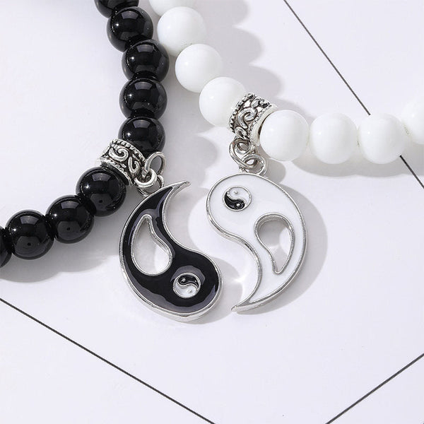 Yin Yang Protection Couple Bracelet - Close-up of black and white stone bead bracelets with ornate silver spacers and yin-...