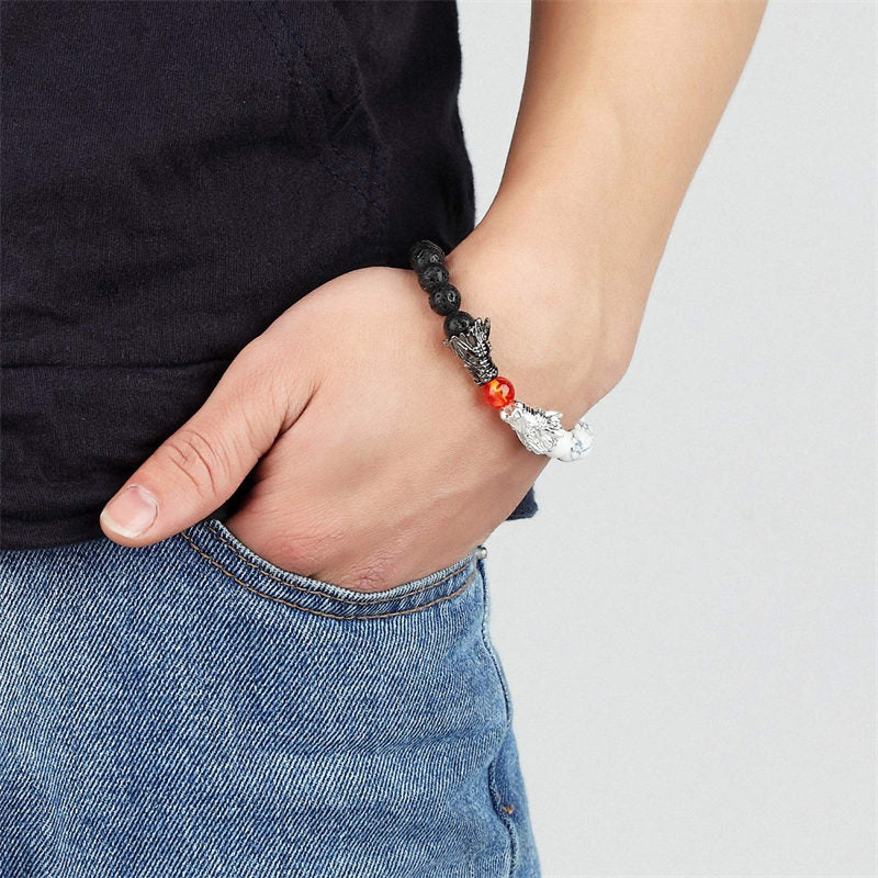 White Turquoise Lava Rock Dragon Bracelet – Worn on wrist showing dragon charm centerpiece on denim, Blessing