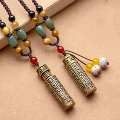 Pair of antique brass Tibetan prayer box necklaces with engraved Sanskrit script, green aventurine, tiger's eye, and bodhi seed tassels on braided cord