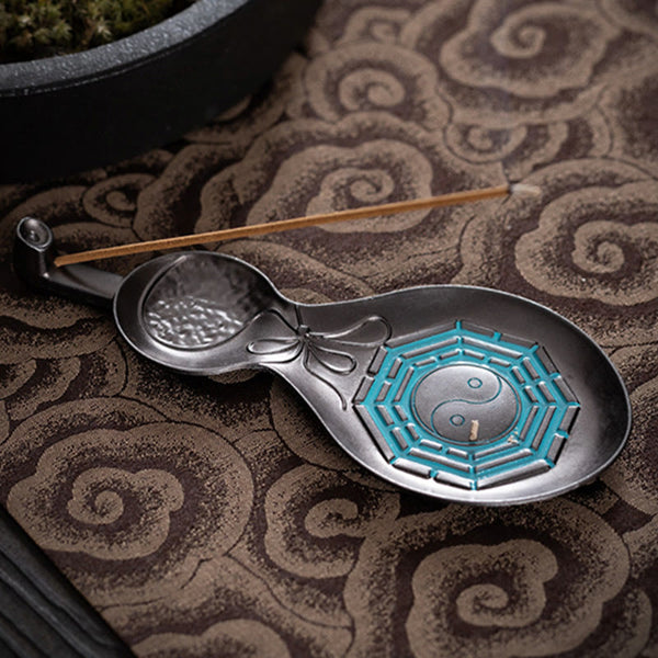 Gourd Yin Yang Bagua Incense Burner – Dark gourd with teal trigram enamel and incense on brown textile, copper burner