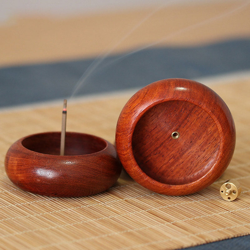 Rosewood Incense Burner – lit bowl with domed lid beside it, nine-hole brass insert on woven mat, serene