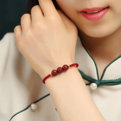 Cinnabar Om Mani Padme Hum Braided Bracelet – Worn on wrist near face with carved red beads, red bracelet
