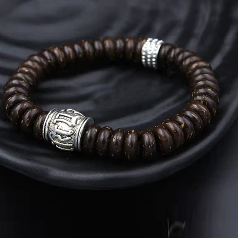 Om Mani Padme Hum Coconut Shell Bracelet – on dark ceramic dish, silver metal accents