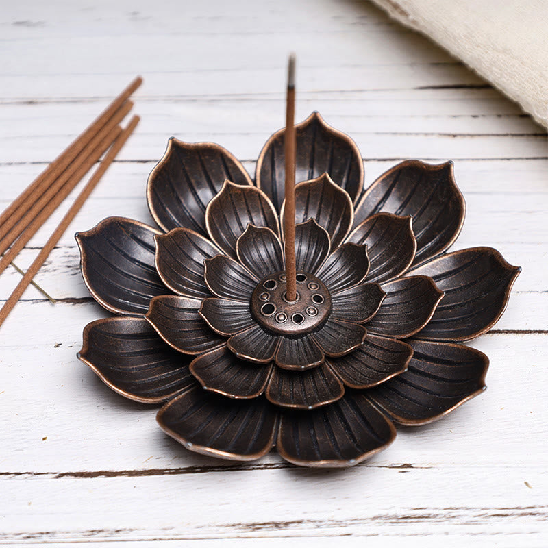 Six-Hole Lotus Incense Burner with smoke, antique bronze flower on white wood, purifying