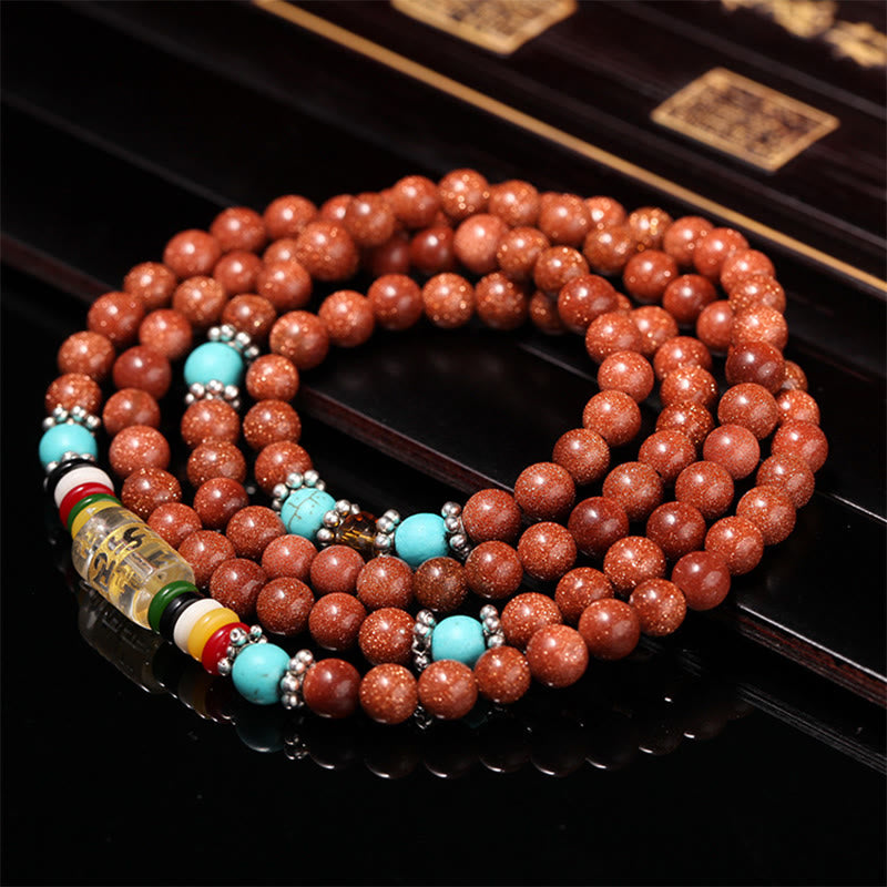 Goldstone Mala Bracelet – coiled mala on dark lacquered surface with traditional box, goldstone beads