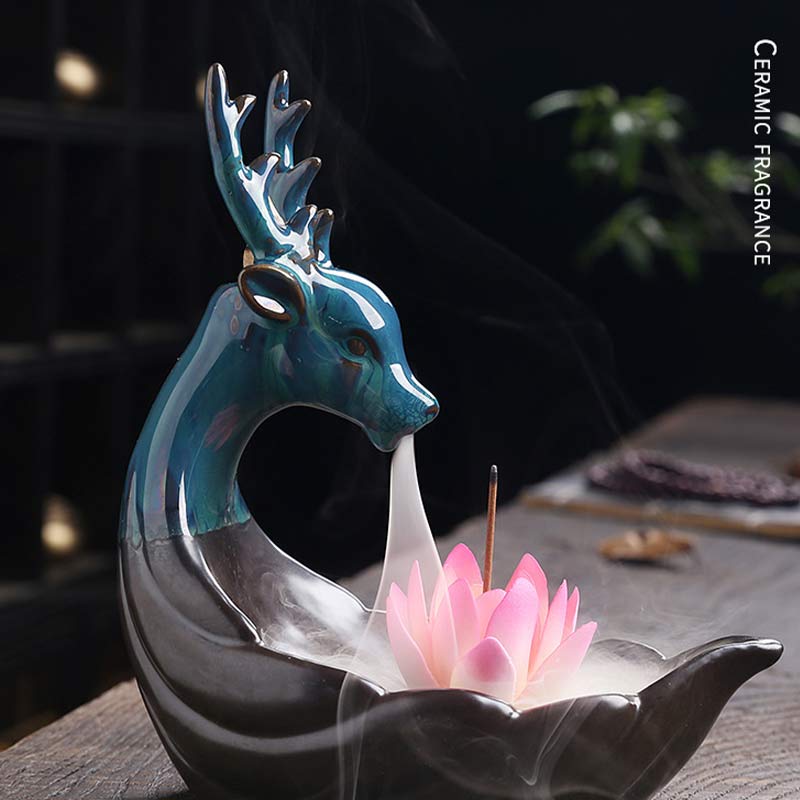 Little Deer Ceramic Lotus Incense Burner – Iridescent teal deer with pink lotus on dark wood, smoke waterfall in action