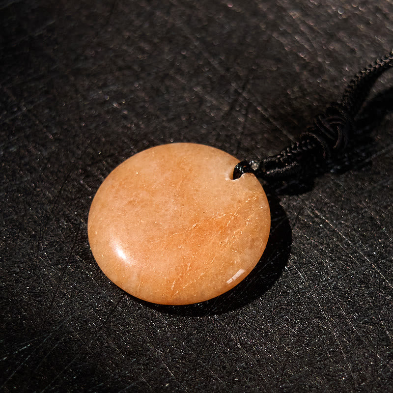 Yin Yang Crystal Necklace – Round peach aventurine pendant with polished glossy finish on black cord, warm orange natural vei