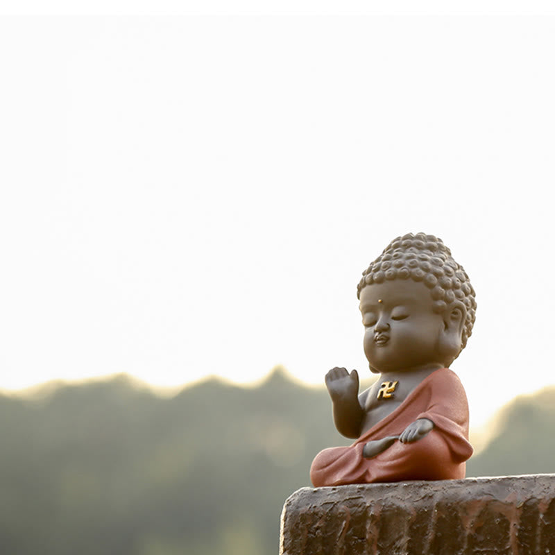 Small Buddha Purple Clay Decoration – outdoor mountain backdrop, low angle on stone ledge, warm backlight, zen retreat vibe