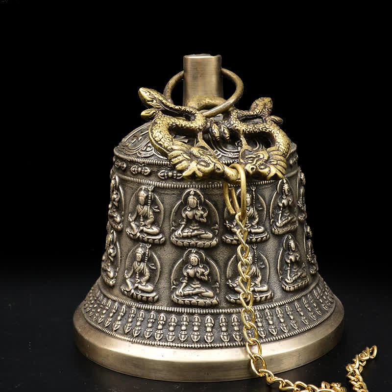 Tibetan Buddha Dragon Wind Chime Bell angled view showing Buddha relief rows, brass chain, black backdrop, meditation
