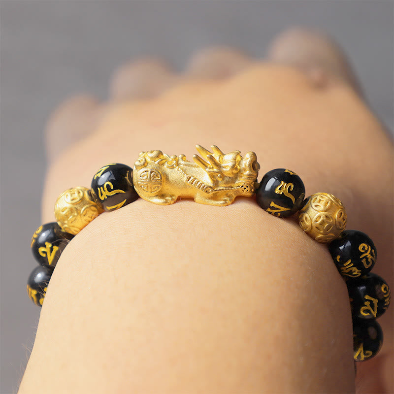 FengShui PiXiu Obsidian Bracelet – wrist closeup gray background gold PiXiu charm, fortune bracelet