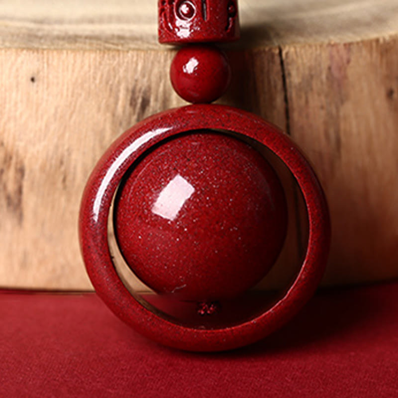 Cinnabar PiXiu Necklace – Extreme close-up of mantra carving and cinnabar texture on wood, spiritual bead