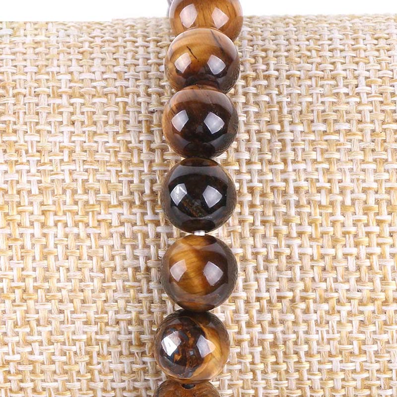 Tree of Life tiger eye bracelet with polished golden-brown chatoyant beads strung vertically, silver-toned metal spacers and tree charm.
