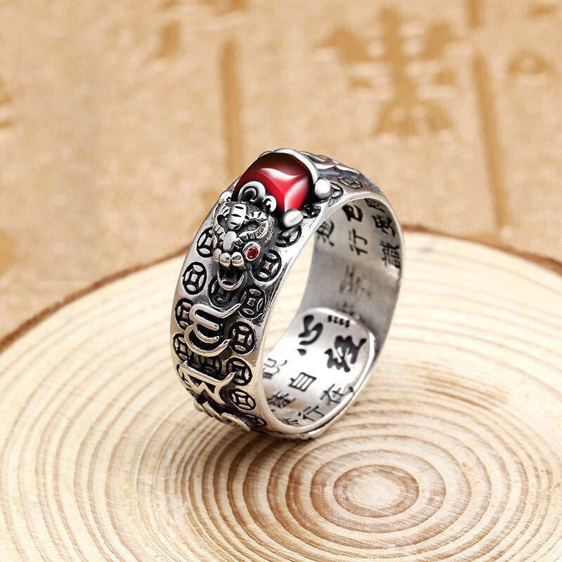 Feng Shui PiXiu Ring – Silver adjustable ring with red stone on textured surface, side angle view