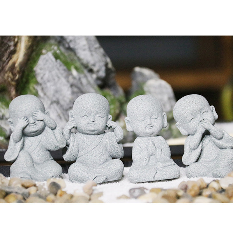 Meditation Monk Statue - Four wise monks on pebbles with rockery and greenery backdrop