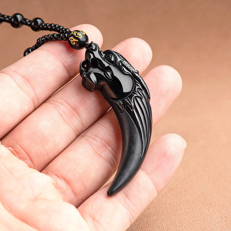 Black Jade Dragon Tooth Pendant – resting on open palm showing scale, gold mantra bead, tangible protection