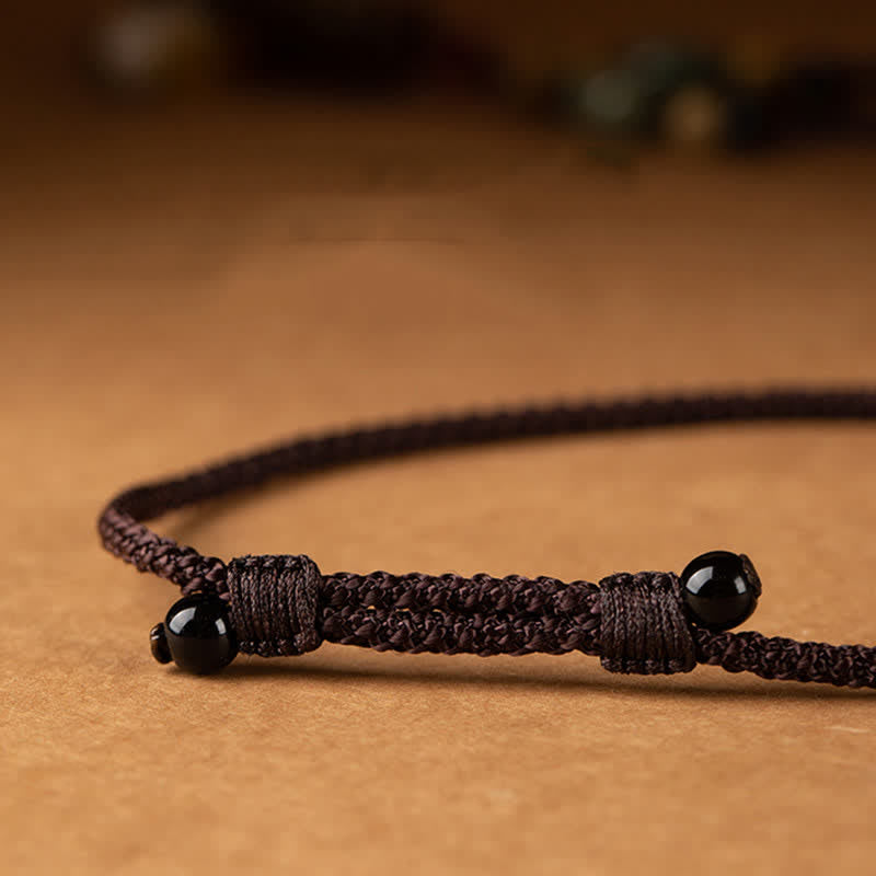 Dark brown braided cord adjustable sliding knot closure with polished black onyx beads, handmade macrame bracelet detail