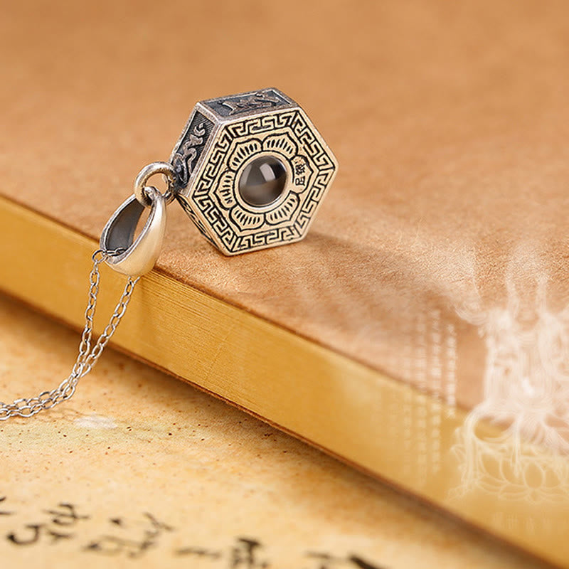 Sterling Silver Mantra Pendant – Artistic shot on calligraphy scroll with misty spiritual atmosphere