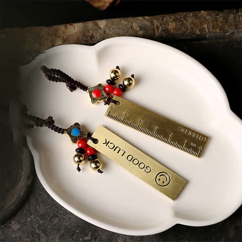 Feng Shui Yin Yang Bagua Keychain - Twin brass pendants with yin-yang and ruler on white dish, brass charm