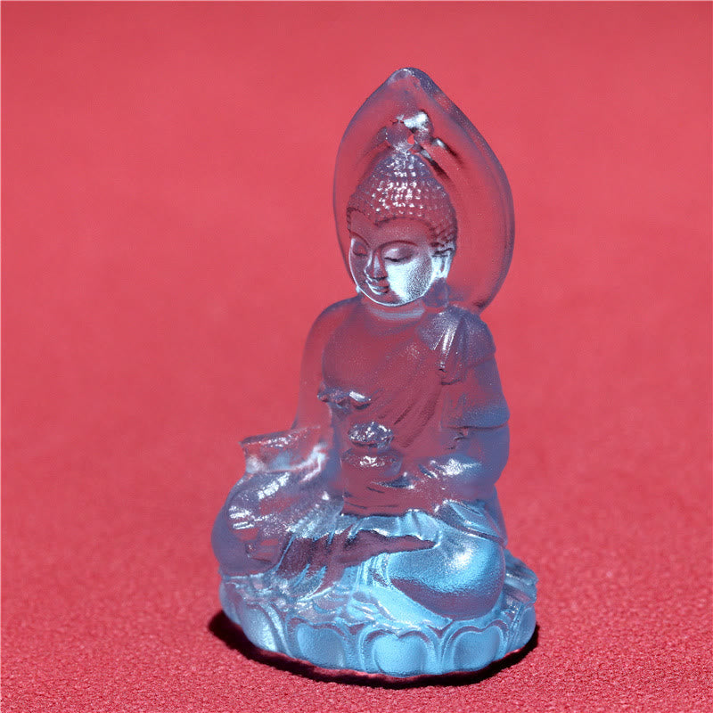 Blue Tathagata Medicine Buddha Liuli Crystal Necklace – small Buddha figurine on lotus base with flowing robes and ushnisha detail, salmon-pink surface studio shot