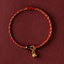 Red Gold Rope Lotus Braid Bracelet - centered flat lay on burgundy with lotus charm, braided jewelry