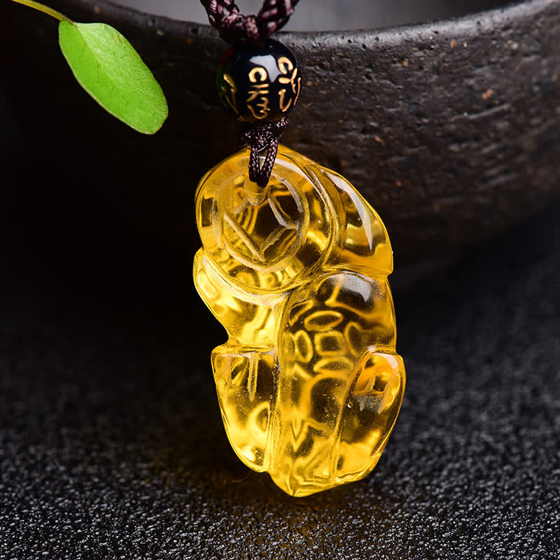 Citrine PiXiu Necklace Pendant – Back view of carved citrine PiXiu near bowl showing detail, prosperity