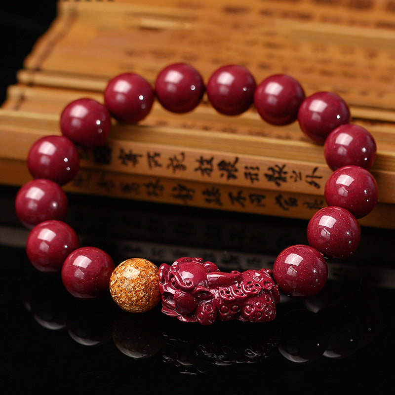 Tibetan Cinnabar PiXiu Bracelet – Red cinnabar beads with gold accent on wooden book, spiritual focus jewelry
