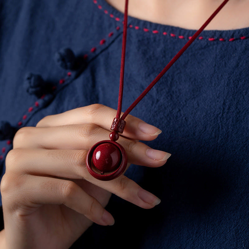Cinnabar PiXiu Necklace – Model wearing with navy blue traditional outfit hand touching pendant, wealth necklace