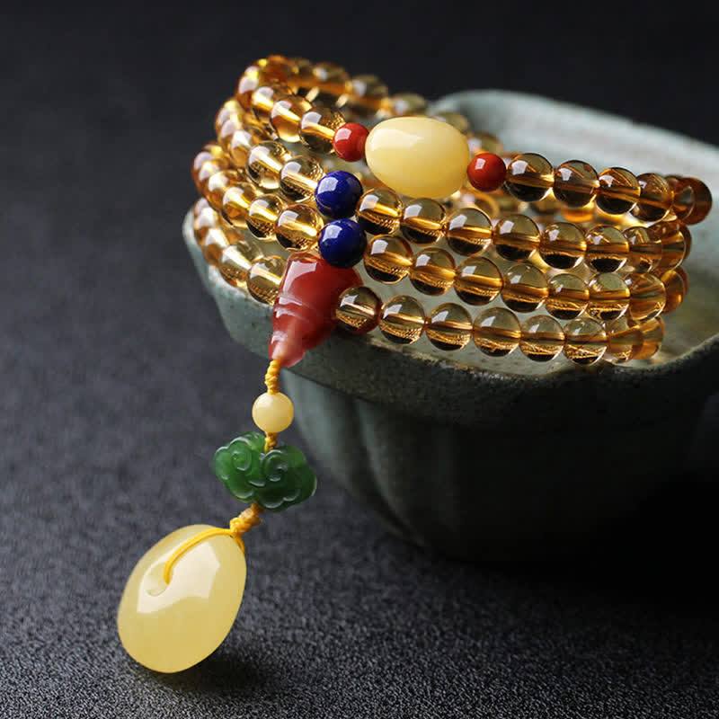 Citrine Mala Bracelet – Coiled citrine mala on gray ceramic bowl, amber and green charm