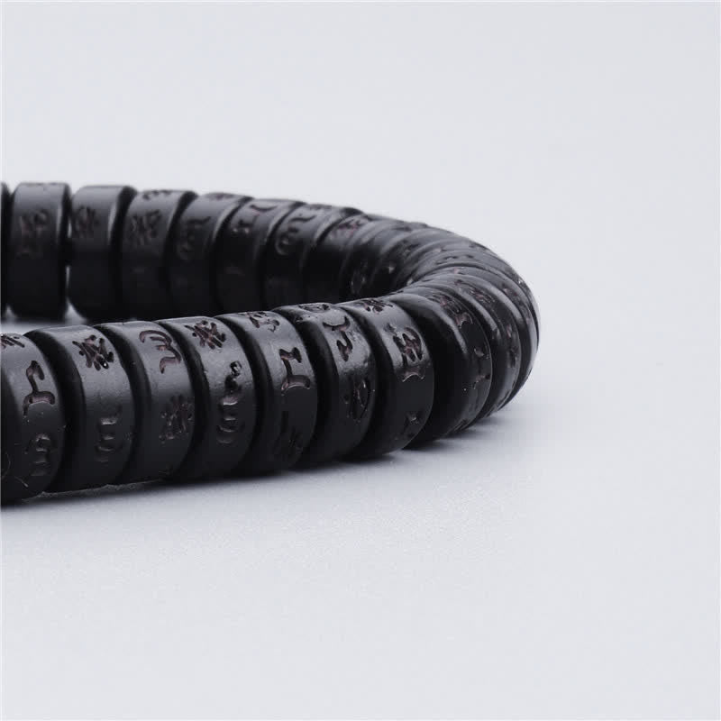 Coconut Shell Mantra Bracelet - Low macro angle of S-curved bead row, carved Tibetan script texture