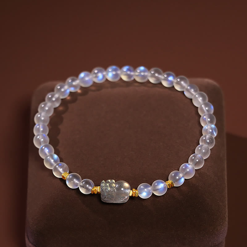 Moonstone PiXiu Bracelet – Moonstone beads with carved PiXiu on velvet stand top view, mindfulness