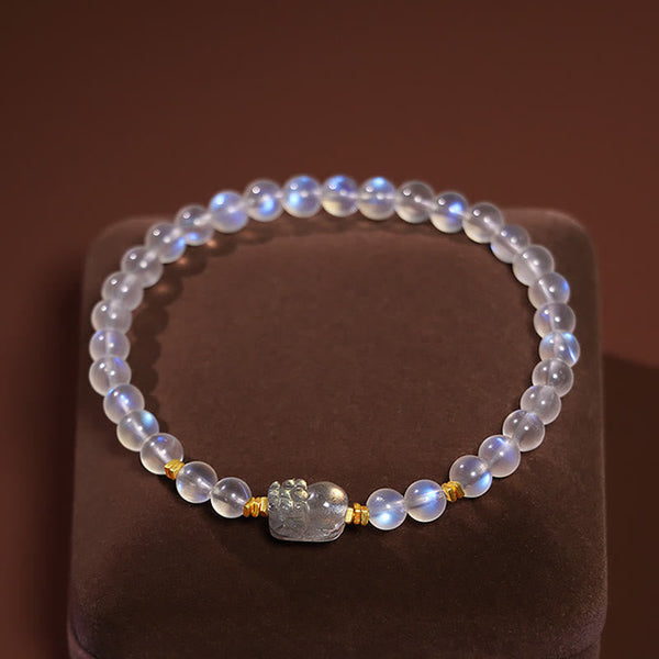 Moonstone PiXiu Bracelet – Moonstone beads with carved PiXiu on velvet stand top view, mindfulness