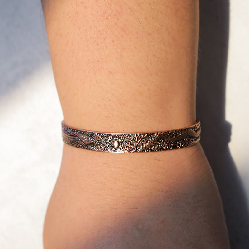 Dragon Phoenix Copper Cuff Bracelet – Worn on wrist showing dragon phoenix relief, artisan copper jewelry, Protection