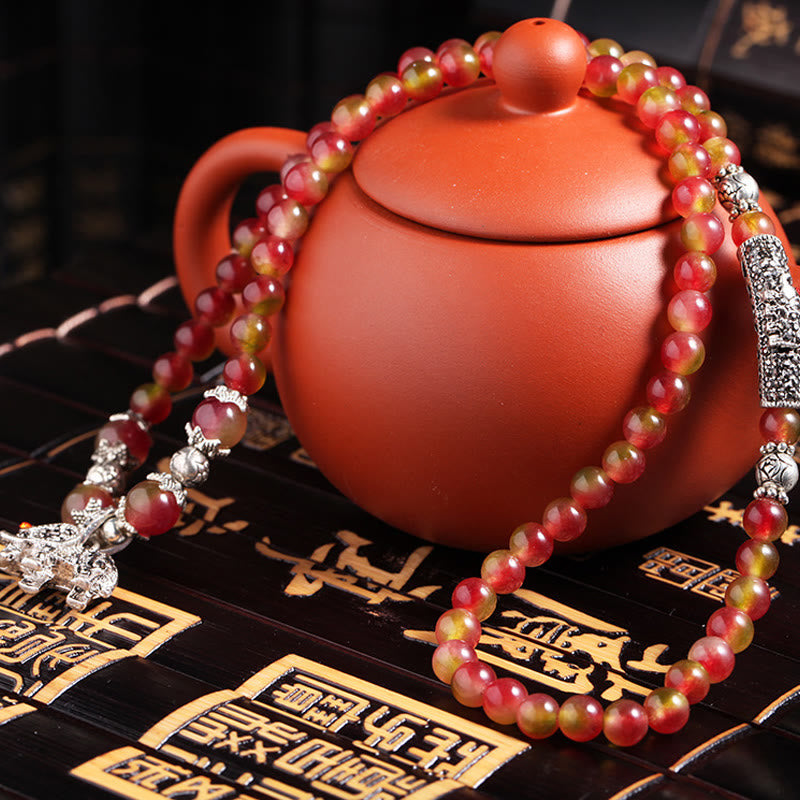 Watermelon Tourmaline Bracelet – Draped around clay teapot on black bamboo mat