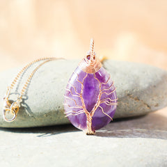 Quartz Crystal Tree of Life Necklace – amethyst pendant on stone prop, low angle, copper wire, spiritual
