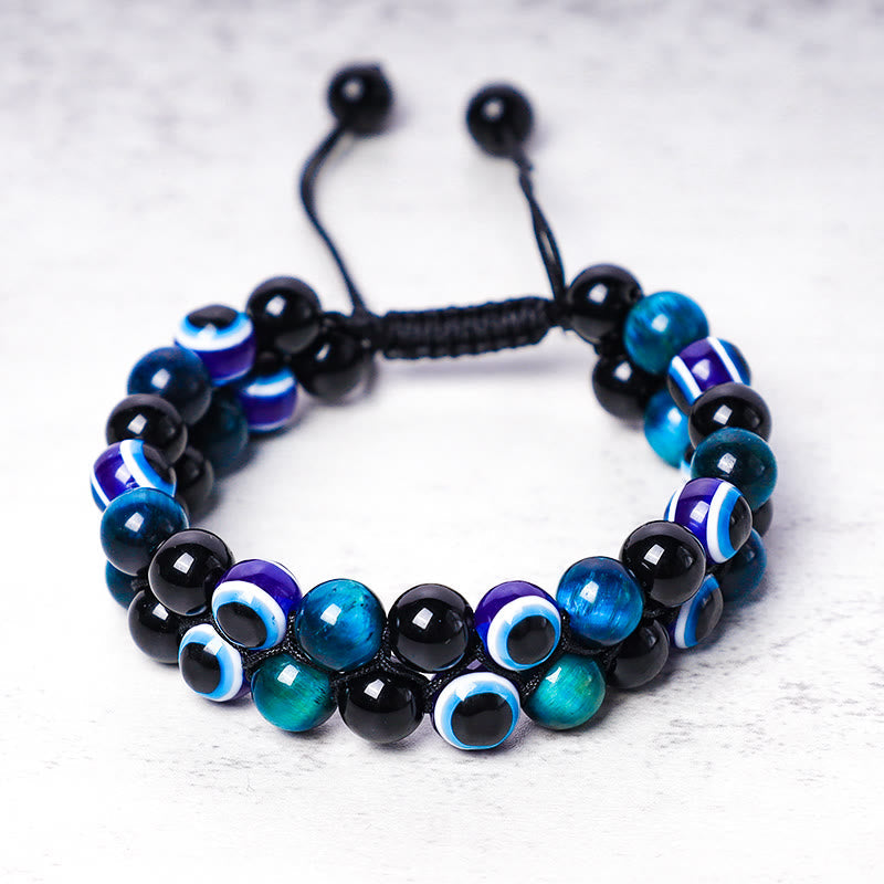 Evil Eye Hematite Tiger Eye Bracelet – double-row black tiger eye beads with blue evil eye charms, white background