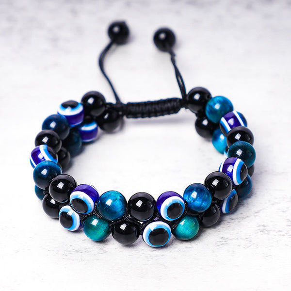 Evil Eye Hematite Tiger Eye Bracelet – double-row black tiger eye beads with blue evil eye charms, white background