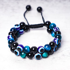 Evil Eye Hematite Tiger Eye Bracelet – double-row black tiger eye beads with blue evil eye charms, white background