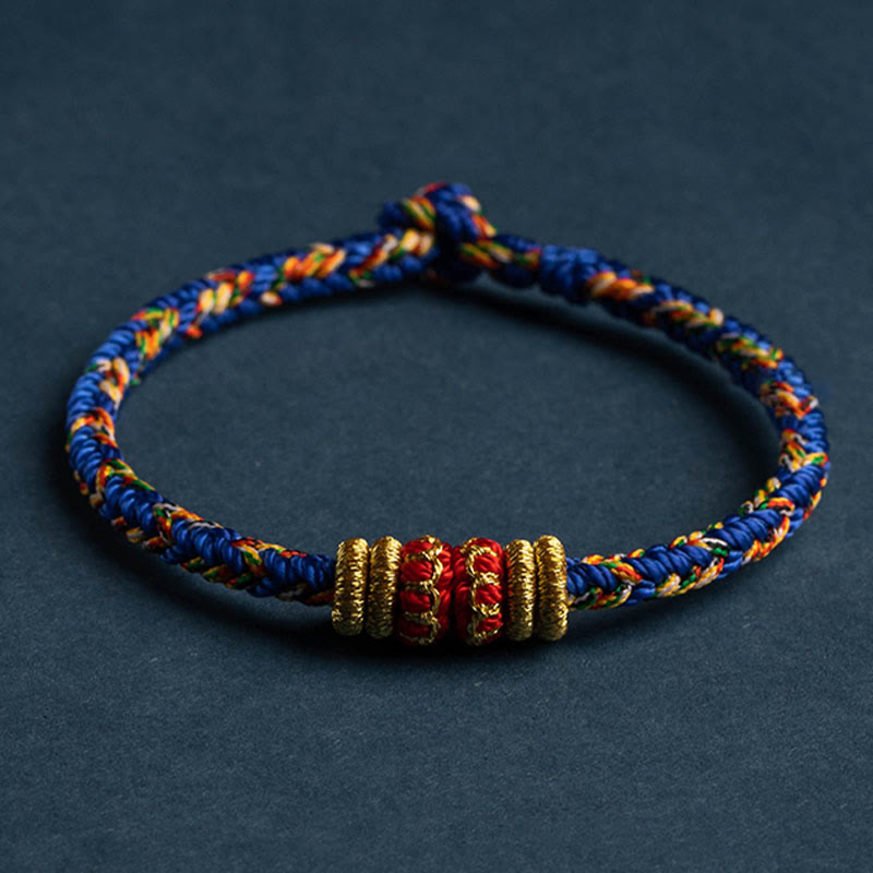 Handmade blue braided cord bracelet with gold coil beads and red lucky center bead, adjustable sliding knot closure, traditional Chinese knot jewelry