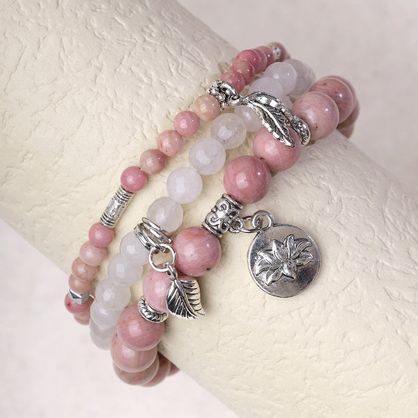 Crystal Lotus Bracelet – rose pink and white opalescent beads on wrist display with silver lotus charm, stacking bracelet