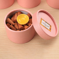 Tibetan incense cones – open pink tube of terracotta cones with yellow ceramic holder, meditative